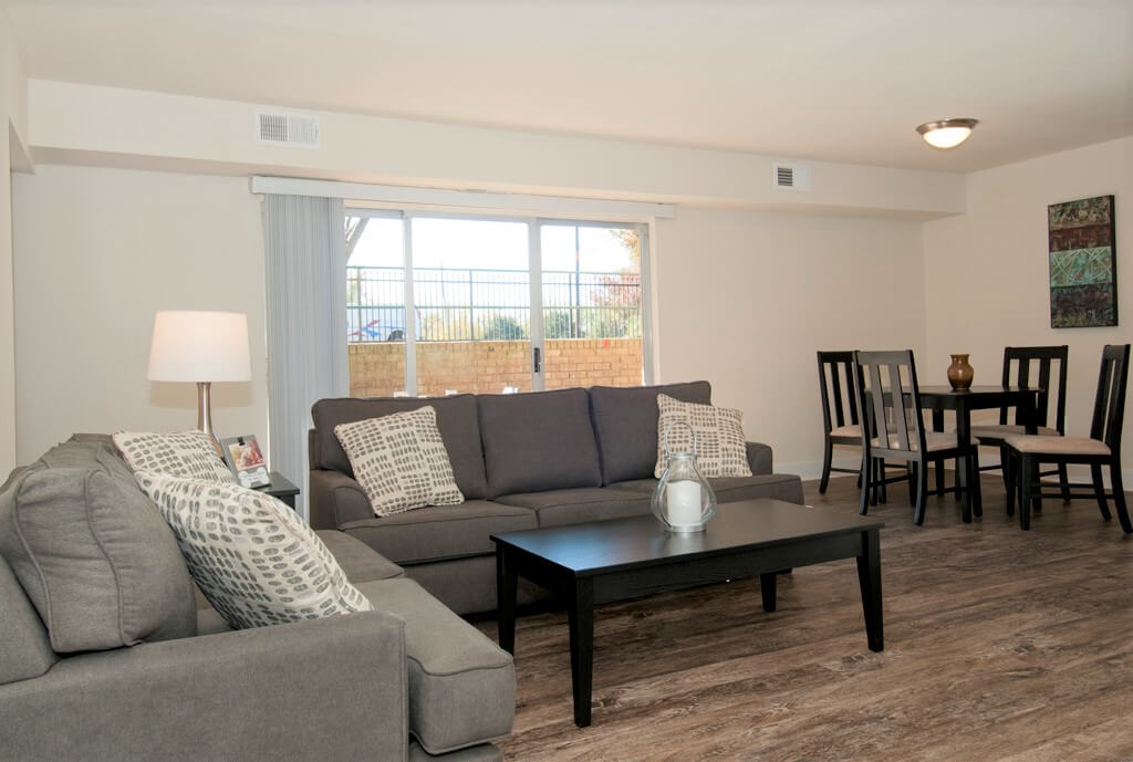 Gray furniture inside spacious living room with connected patio