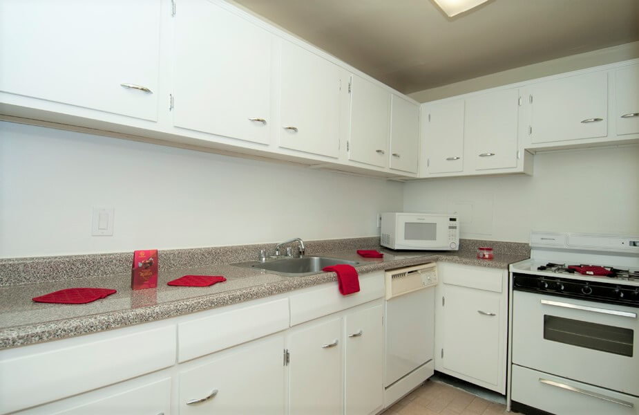classic kitchen with white cabinets and gas stove at Auden Place